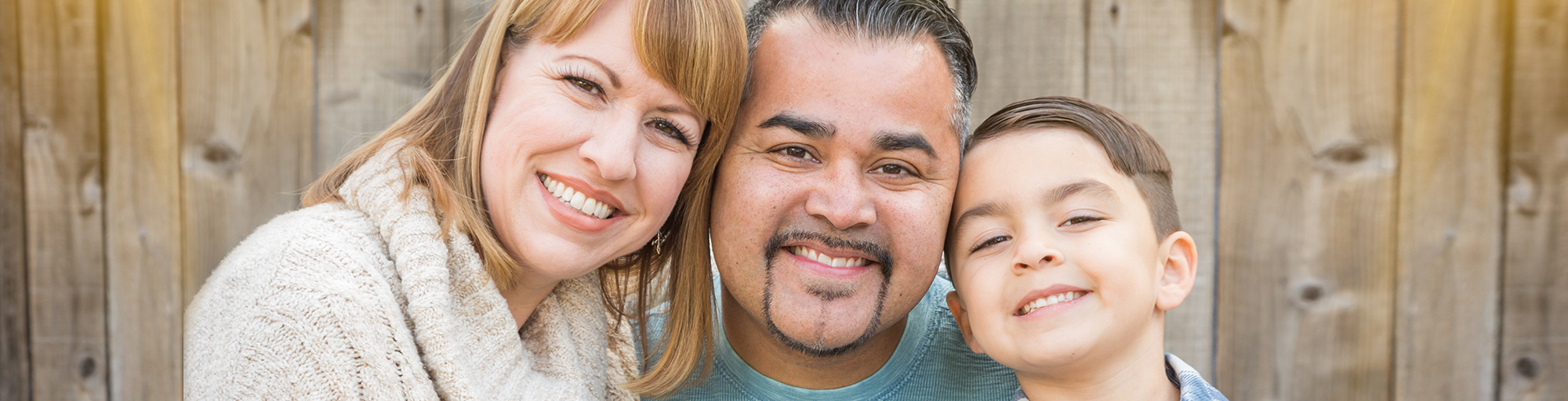 Retrato de una madre, un padre y un hijo sonriendo