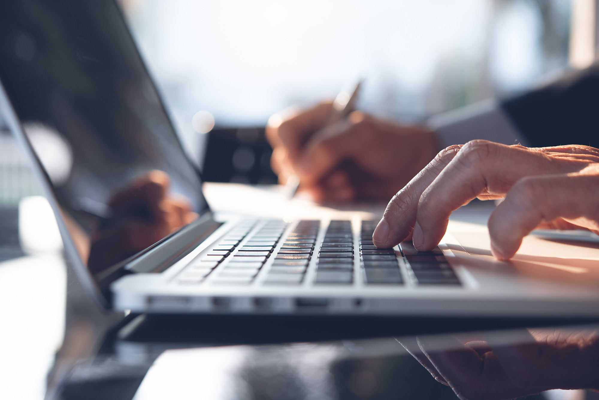 Fingers typing on a laptop.