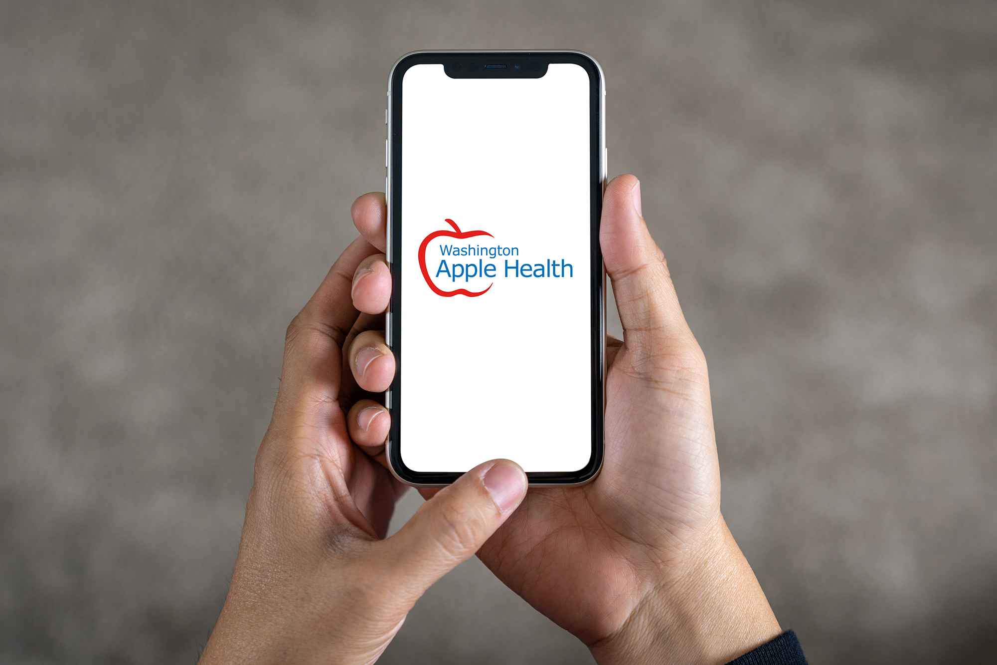 Vista desde arriba de manos sosteniendo un teléfono inteligente con el logotipo de Apple Health