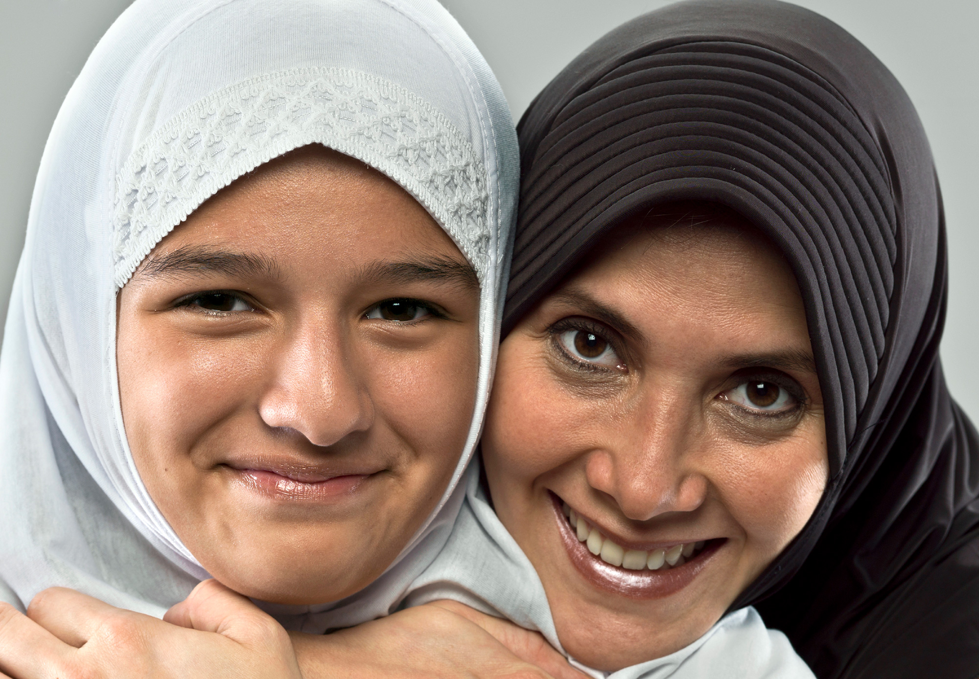 Retrato de dos mujeres con la cabeza cubierta, sonriendo.