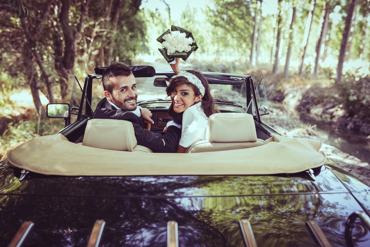 two people in a car looking back smiling